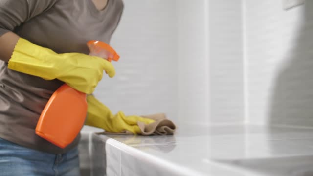 Woman cleaning kitchen counter with Spray